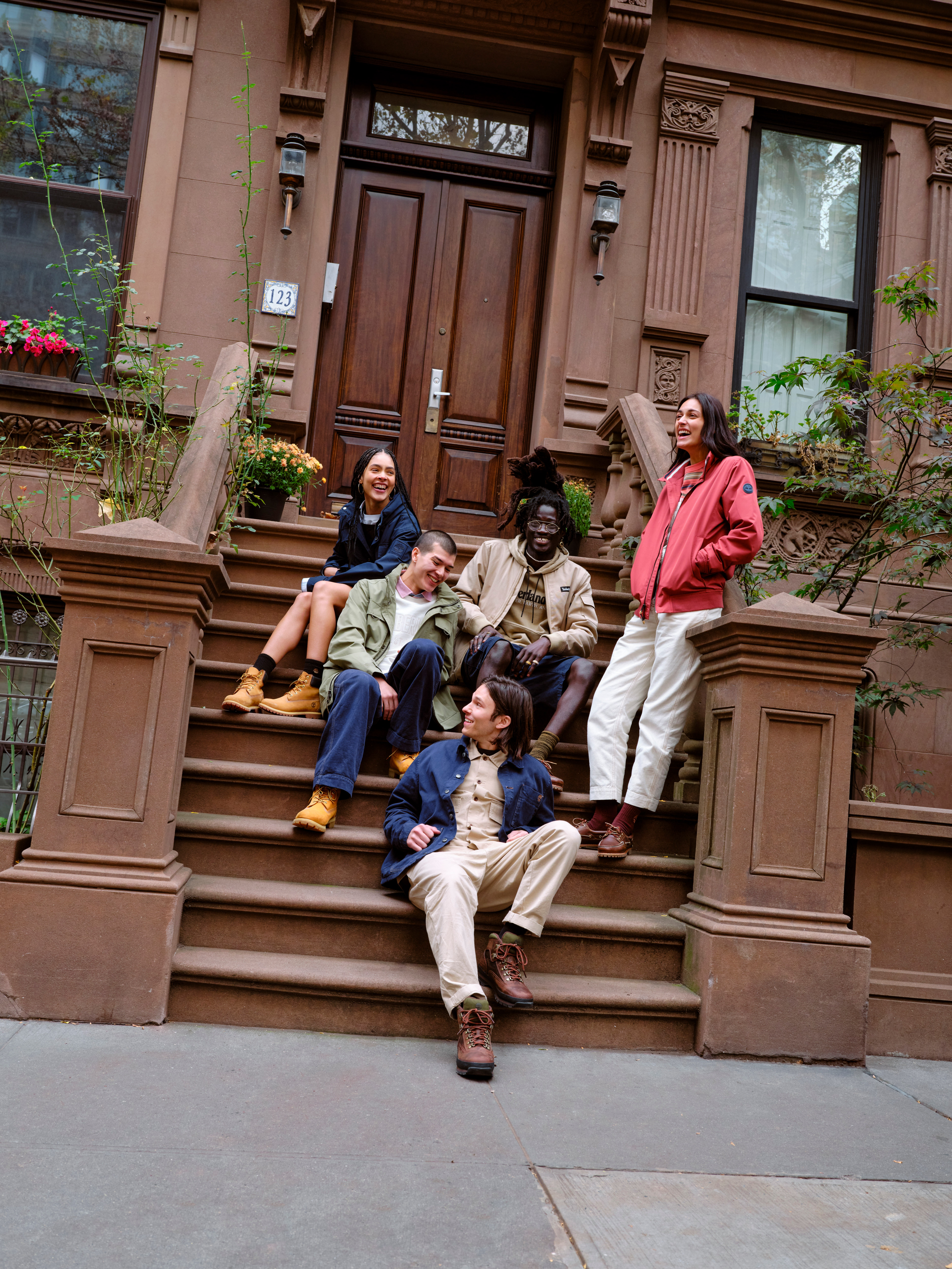 People in Timberland boots sitting on steps in front of building