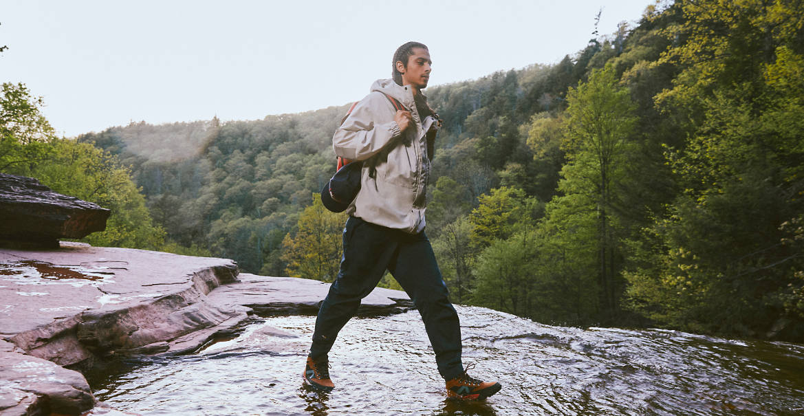 Man hiking through water in Timberland hiking boots