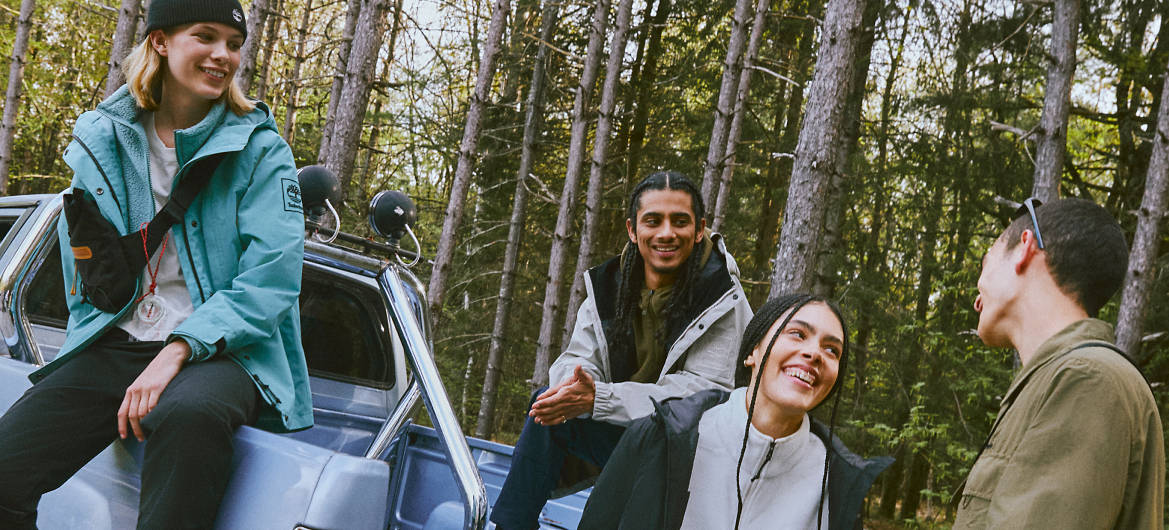 People in Timberland clothing sitting by car